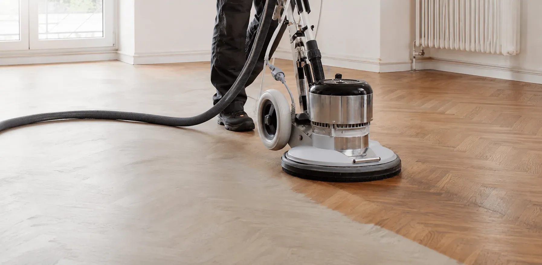 Dust-controlled sanding equipment restoring a wood floor